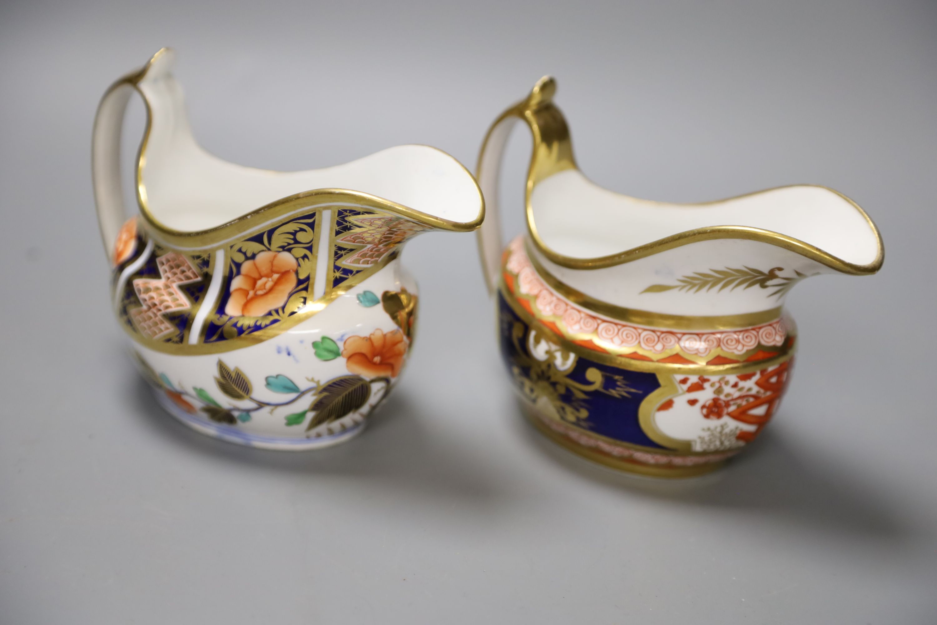 A Spode cream jug painted in imari style with the dollar pattern 715 and another Spode cream jug painted in imari style